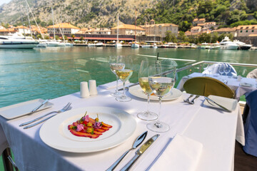 Fish filet on a plate served on a restaurant table with wine