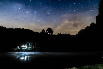 lake at night with dark sky full of stars and cabbin in front of lake, dam of the llano, villa del...