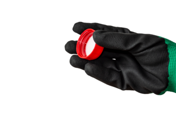 A hand in a working rubberized glove holds a red cap. Isolate on a transparent background.
