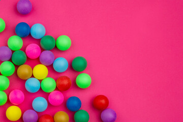 Abstract colored balls background. Multi-colored taw toy scattered on bright paper. Base for design nice backdrop, wallpaper, poster. Noisy surface texture