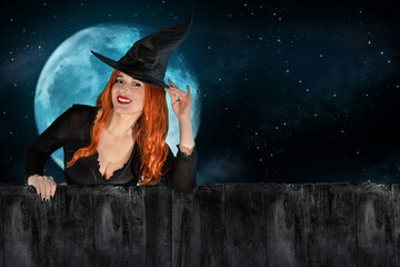 Halloween Witch peeking out behind a fence or wooden wall. Female wizard fairy character. All Saints' Day. Fantasy gothic red-haired sorceress girl dressed in black carnival costume - Powered by Adobe