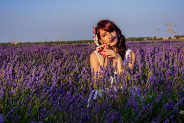 Woman smelling a flower in a lavender flower field.