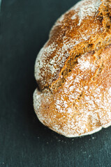 a loaf of freshly baked homemade bread on a black background from the oven baking