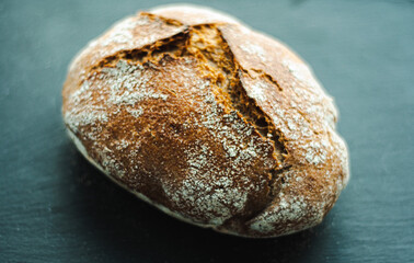 a loaf of freshly baked homemade bread on a black background from the oven baking