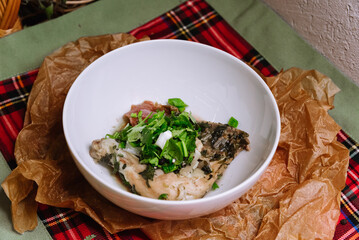 Poultry dish. Chahohbili chicken in a sauce of aromatic spices, onions, fresh parsley and coriander greens, and garlic. Portion in a deep white bowl.