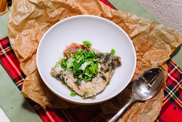 Poultry dish. Chahohbili chicken in a sauce of aromatic spices, onions, fresh parsley and coriander greens, and garlic. Portion in a deep white bowl.