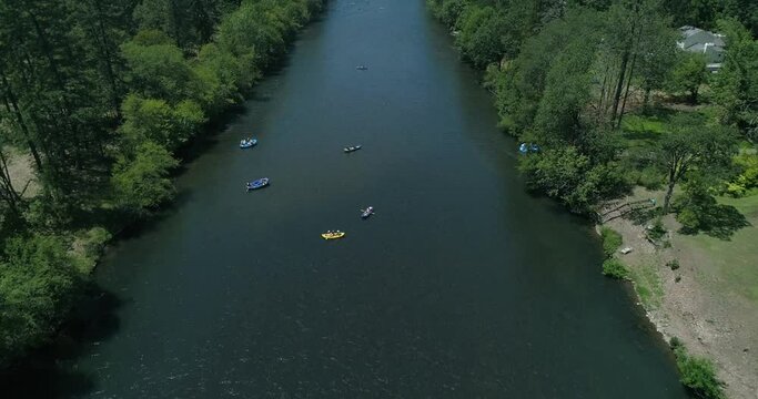 Moving drone shot overlooking a group rafting down a beautiful river in Southern Oregon.