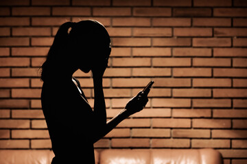 Sad emotional woman holding phone getting bad news 