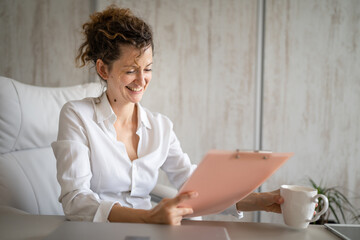 One young business woman working in the office holding clipboard