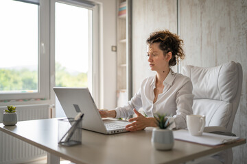 One young business woman back to work in the office working on laptop