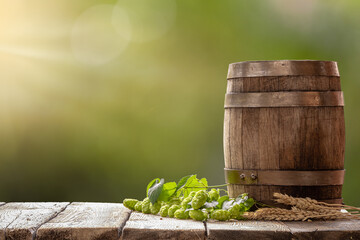 Oktoberfest concept background. Traditional oak barrel and beer brewing ingredients- hop cones and...