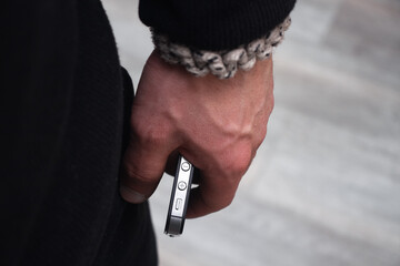 Fashionable bracelet for men. A man's hand with a bracelet and a phone