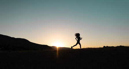 girl runs at sunset in the mountains.