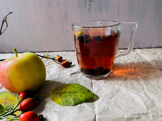 a cup of tea with a branch of rose hips. A composition for teaching drawing