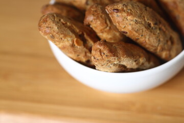 small French baguettes in a bowl against wooden background flat lay