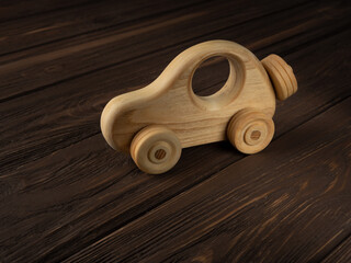 Wooden toy car on a dark background