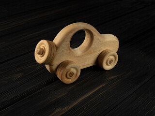 Wooden toy car on a dark background