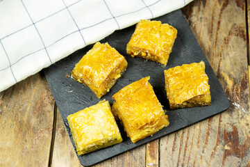 Pistachio baklava dessert on wood table. Traditional Turkish cuisine delicacies