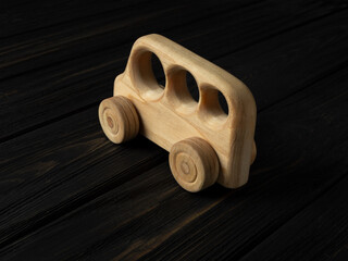 Wooden toy car on a dark background