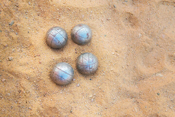 Fototapeta na wymiar old rusty boccia balls lie on the sand