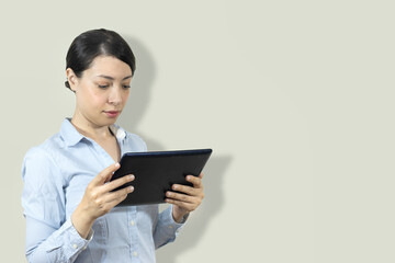 Elegant businesswoman standing in office with digital tablet