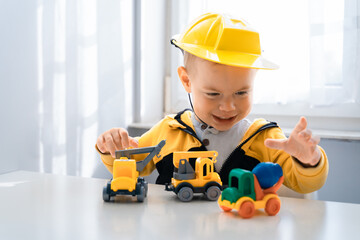 Child play with construction machinery at home, dreams to be an engineer. Little builder. Education, and imagination, purposefulness concept. Boy with digger