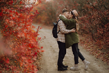 Happy couple in love newlyweds in casual clothes travel together, hike and walk in the autumn...