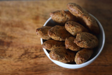 small French baguettes in a bowl against wooden background flat lay