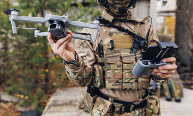 Fototapeta premium Modern army soldiers using aerial drone for artillery guidance and scouting view enemy positions in military operation