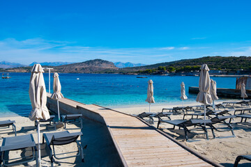 Fototapeta premium Beach with umbrellas and deck chairs in Ksamil in Albania