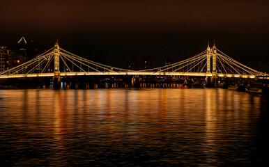 View of the famous Chelsea Bridge over the River Thames illuminated at night in London City