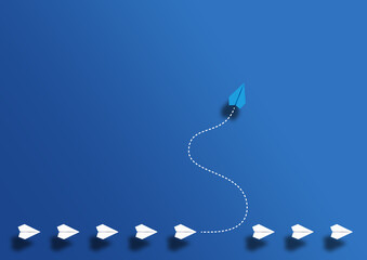 paper planes in a row and one paper glider going in different direction above blue background,...