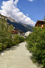 Fototapeta na wymiar The Arve River that crosses the mountain town of Chamonix-Mont-Blanc with the Alps range in the background in summer, Haute Savoie, France