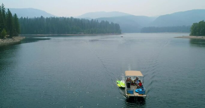 Sweeping drone shot of a boat in a lake on a summer day. 