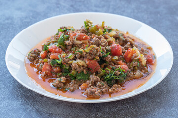 Ground beef, onion, tomato and paprika and a bowl of delicious spicy hot pepper con carne.