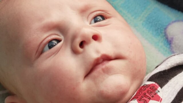 4k footage video. Close up newborn baby child lying in baby carriage stroller buggy having fun playing, looking at her mother, smiling infant. Outside walking in pushchair, fresh air

