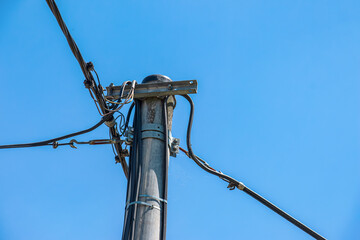 Obraz premium Electric pole power lines outgoing electric wires againts on cloud blue sky.