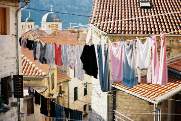 Multi-colored linen hangs on ropes between old houses. Kotor, Montenegro