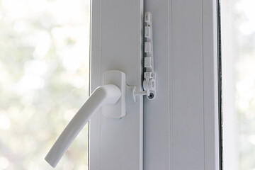 Close-up of a balcony door handle, double-glazed window fixing with a latch and a comb, a door frame. The concept of repairing doors and windows of a house