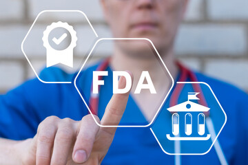 Doctor using virtual touchscreen presses abbreviation: FDA. Concept of FDA Food and Drug Administration Health Product Standard Control System.