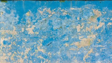 Pared azul desgasta con pintura desconchada en frontón