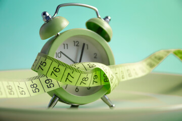 Plate alarm clock, measuring tape on a color background
