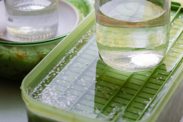 Pickling sauerkraut in plastic containers on the windowsill, glass jars with water, close-up. The concept of food from fermented canned vegetables