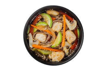Instant soup, noodles wok, with vegetables, herbs and sesame. In a black round plate. On a white background.