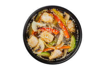 Instant soup, noodles wok, with vegetables, herbs and sesame. In a black round plate. On a white background.