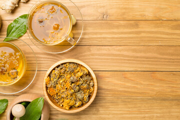 Herbal tea with ingredients on wooden background, top view