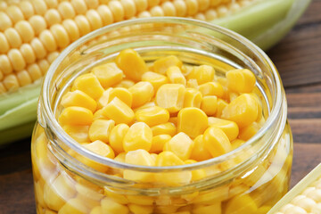 Pickled sweet corn in glass jar closeup, fresh and cooked corn on cobs.