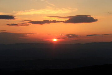 Sunset behind a layer of mountains with beautiful orange colors 
