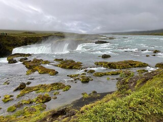 Dettifoss Island (Europa) Isländischer Wasserfall in der Natur mit Wiese, Moos, Blauem Wasser, Felsen, Basaltsäulen, Schlucht, Seitenansicht 