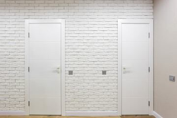 Classic white interior doors and white brick wall